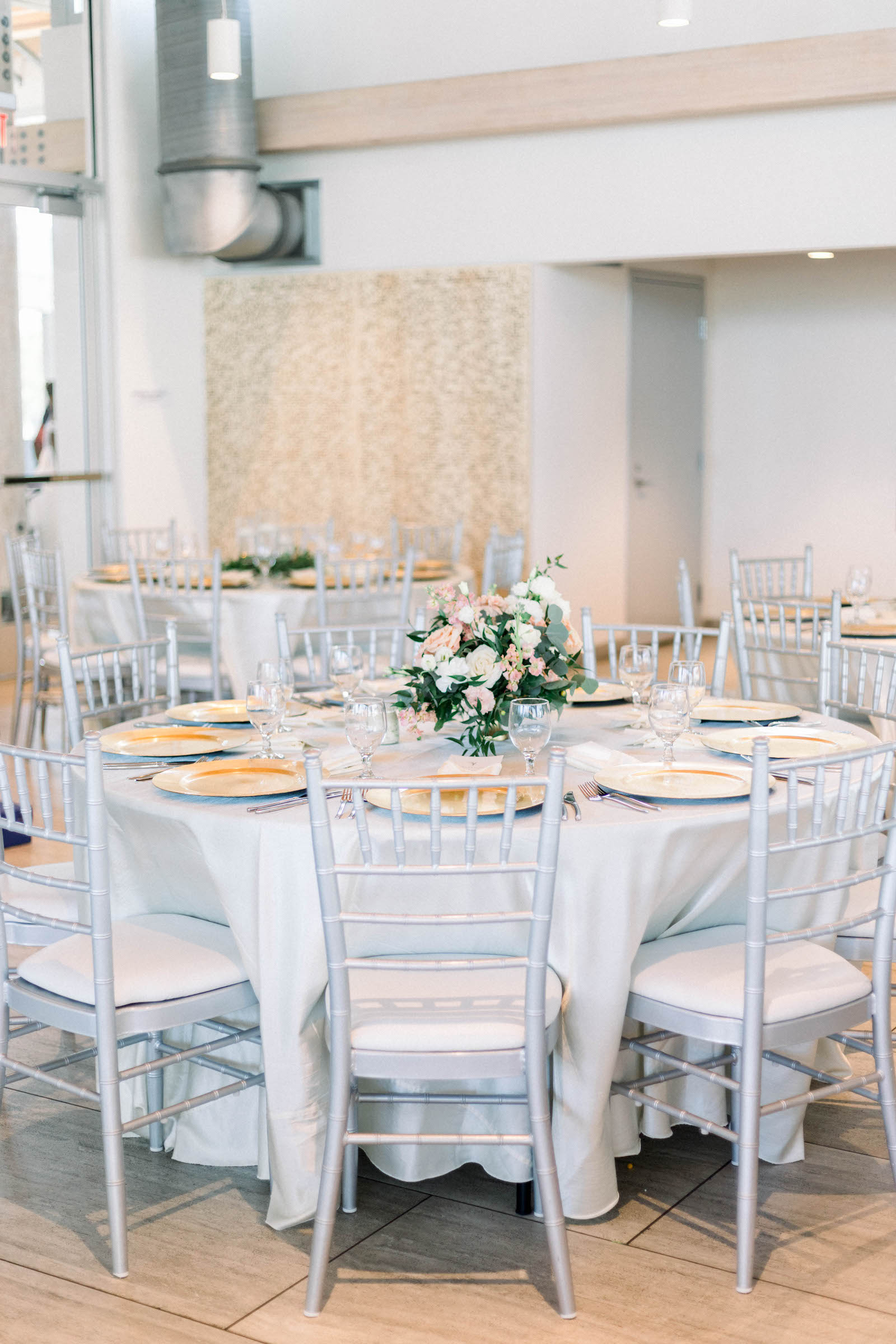 Blush and White Floral and Greenery Centerpiece on Round Table with White Linen and White Chairs | Tampa Rentals Kate Ryan Event Rentals | | Caterer Elite Events Catering