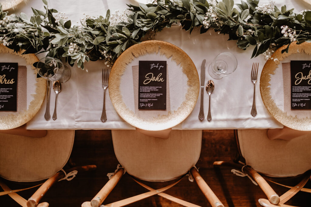 Neutral Boho Modern Wedding Reception Decor, Clear Glass with Gold Splash Painted Edge Charger, Black and Gold Foil Stationery, Greenery Leaves and Baby's Breathe Table Runner Garland | Tampa Bay Wedding Rentals Gabro Event Services | St. Pete Wedding Planner Taylored Affairs