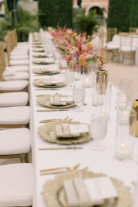 Vibrant Boho Wedding Reception Decor, Wedding Party Head Table, Gold Chiavari Chairs, Low Hot Pink and Red Roses, Pampas Grass Low Floral Centerpieces, Hanging String Lights, Greenery Hedge Wall | St. Petersburg Historic Wedding Venue The Don CeSar
