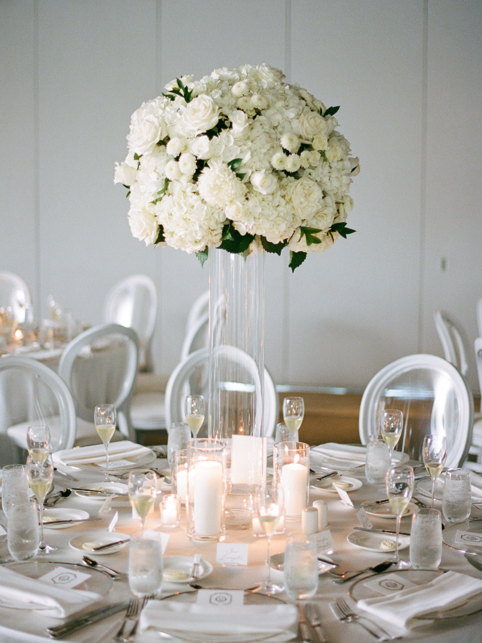 Luxurious Formal All White Wedding Reception Decor, White and Acrylic Dining Chairs, Tall Glass Cylinder Vase with Lush Crisp White Hydrangeas, Spray Roses, Candles | Tampa Bay Wedding Florist Bruce Wayne Florals | Wedding Planner Parties A'la Carte | Wedding Rentals Gabro Event Services