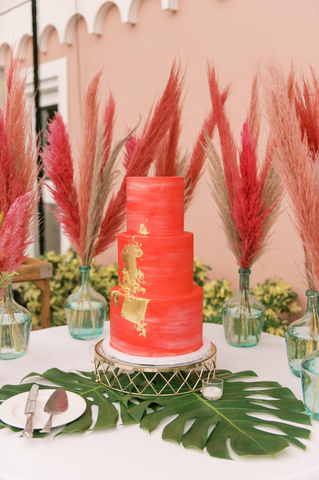 Three Tier Red and Gold Foil Wedding Cake, Monstera Leaves, Red and Hot Pink Pampas Grass in Vases | Tampa Bay Wedding Cake The Artistic Whisk