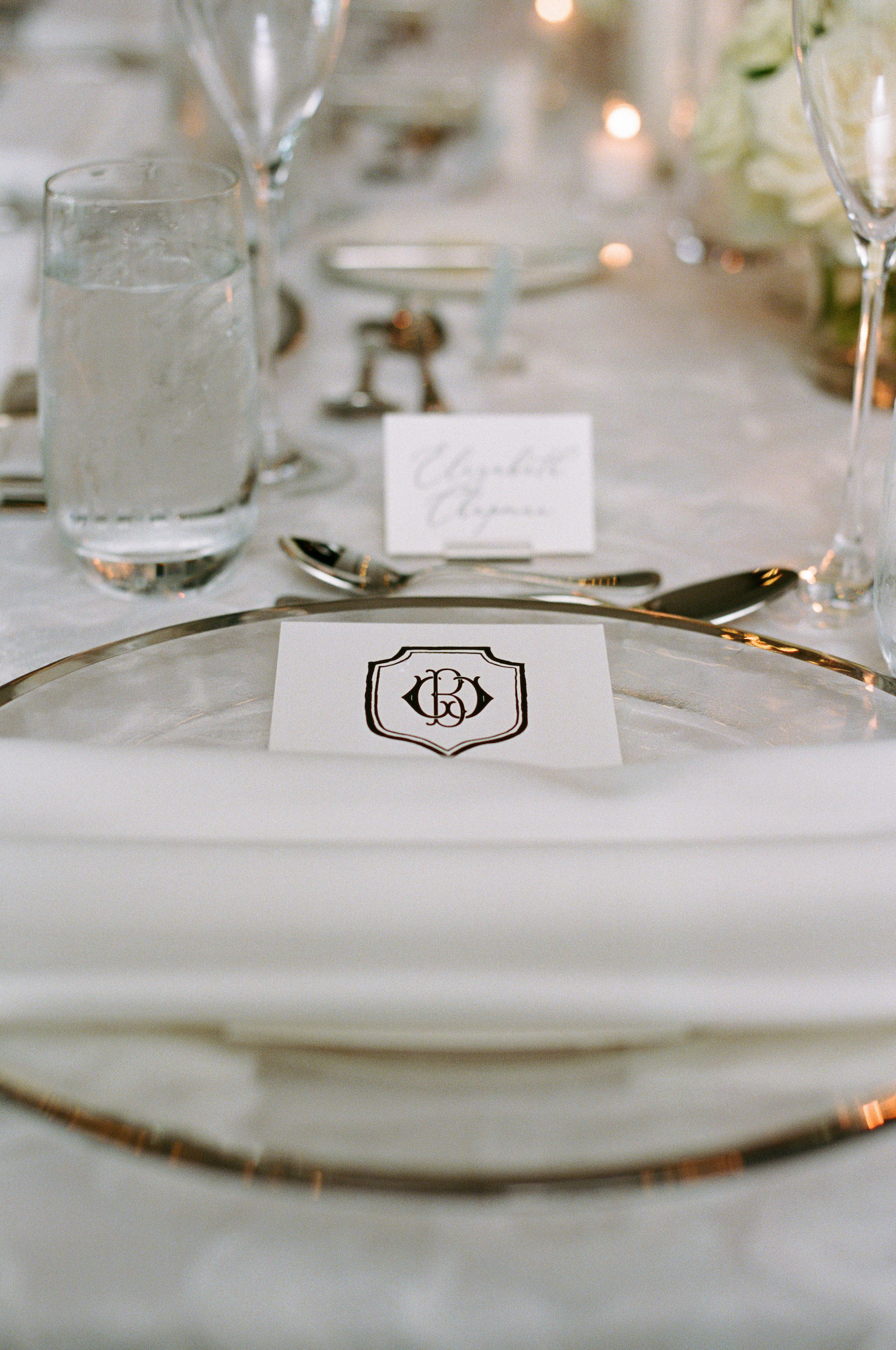 Luxurious Formal All White Wedding Reception Decor, Gold Rimmed Clear Glass Charger with Custom Stationery | Tampa Bay Wedding Planner Parties A'la Carte | Wedding Rentals Gabro Event Services
