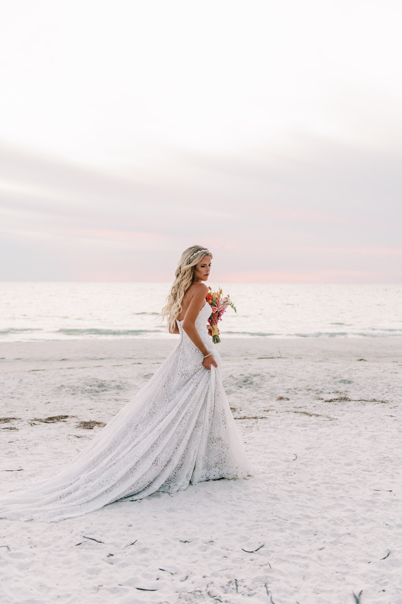 Vibrant Boho Bride Walking on Beach During Sunset | Tampa Bay Wedding Hair and Makeup Femme Akoi Beauty Studio