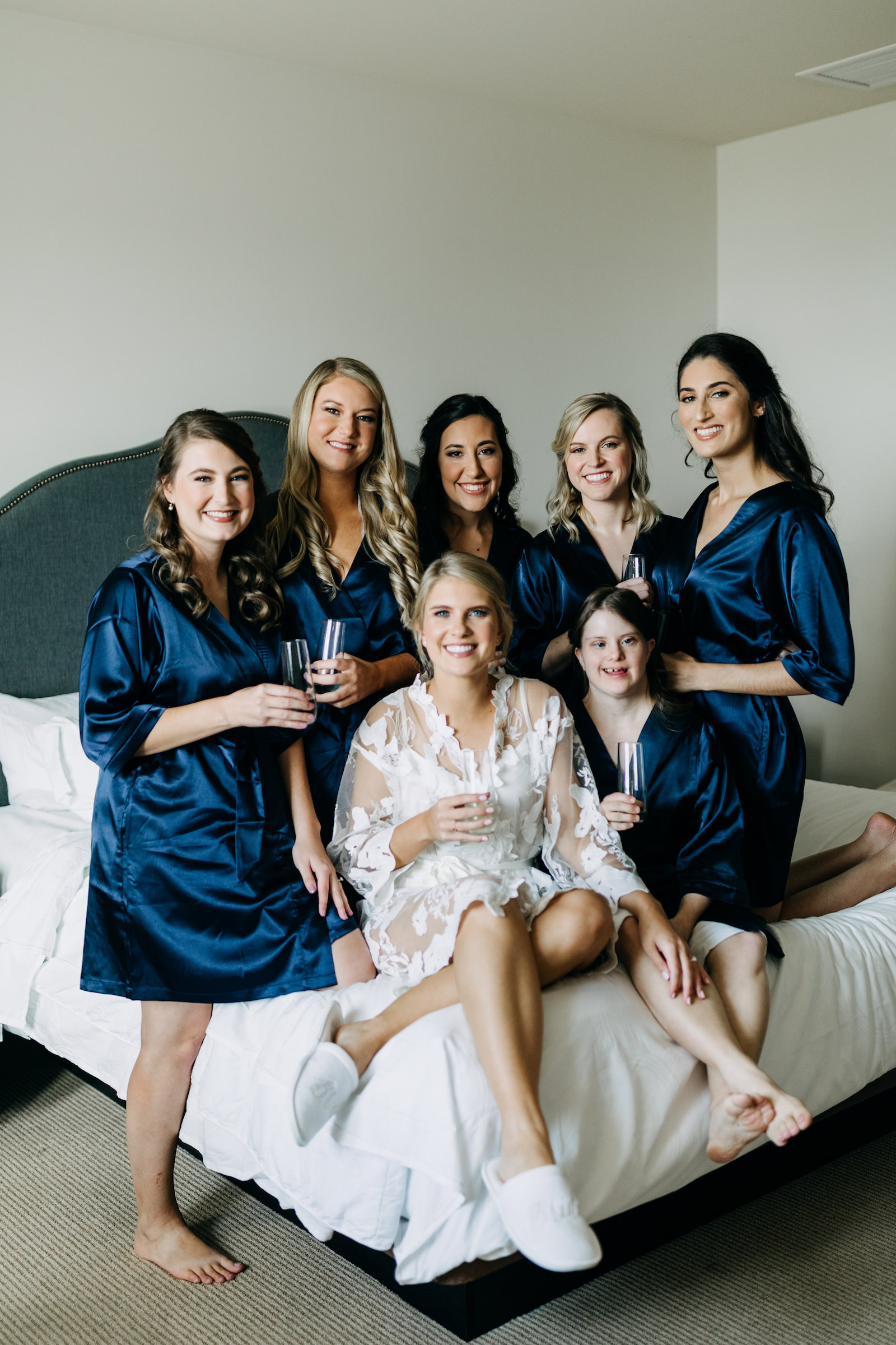 Florida Bride Getting Wedding Ready on Bed with Bridesmaids in Navy Blue Robes | Tampa Bay Wedding Photographer Amber McWhorter Photography