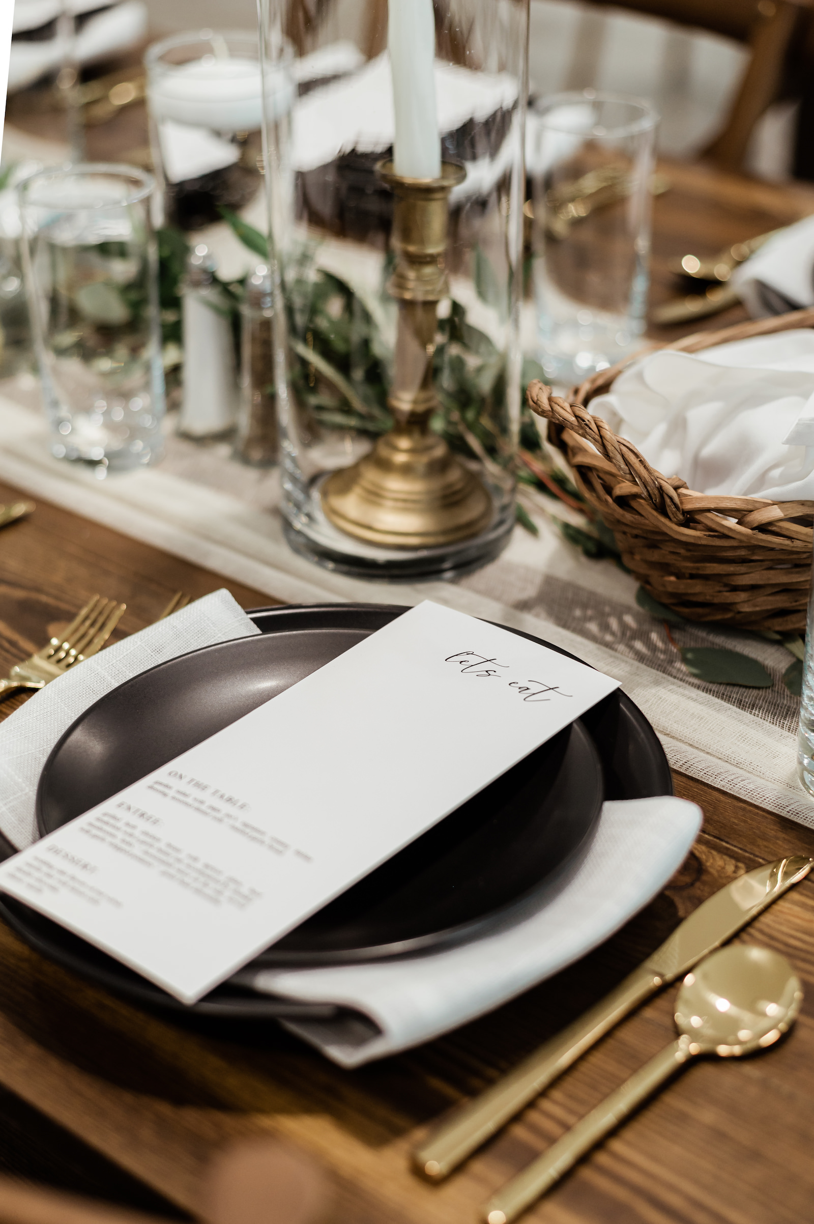 Modern Timeless Wedding Reception Decor, Black Plates with White Menu, Gold Flatware, Gold Candlesticks, Greenery Garland Table Runner