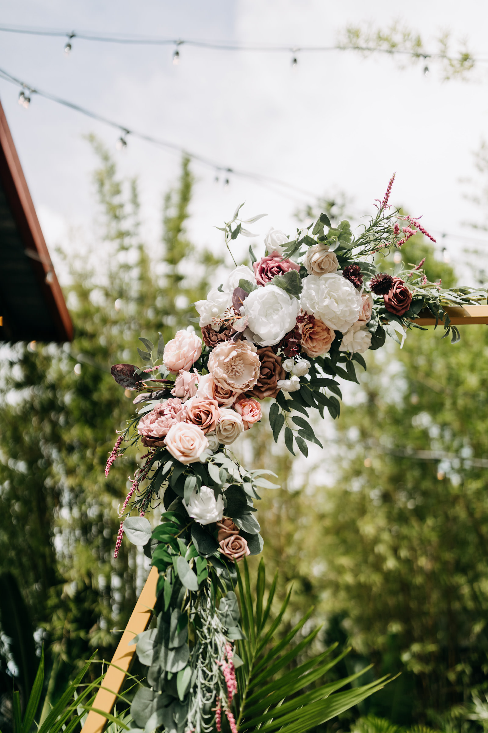 White and Pale Pink Flowers with Greenery on Gold Wedding Ceremony Arch
