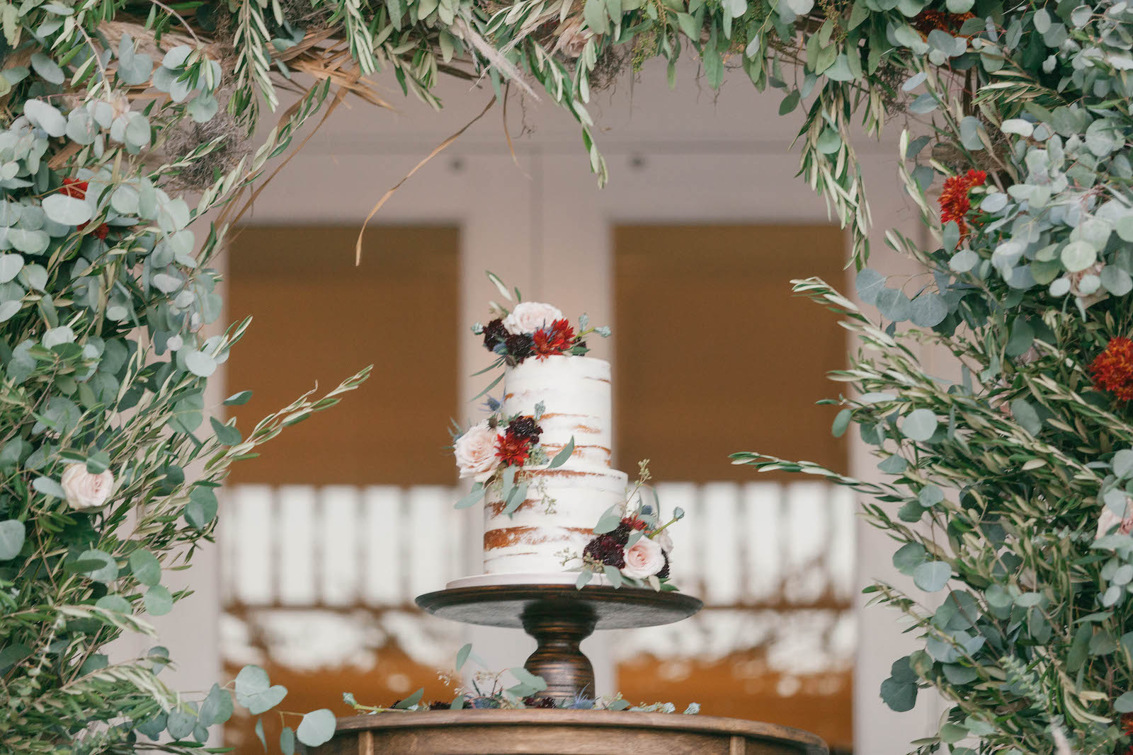 Boho Garden Wedding, Two Tier Semi Naked Wedding Cake with Real Blush Pink Roses, Red and Dark Purple Flowers, Greenery and Eucalyptus Arch