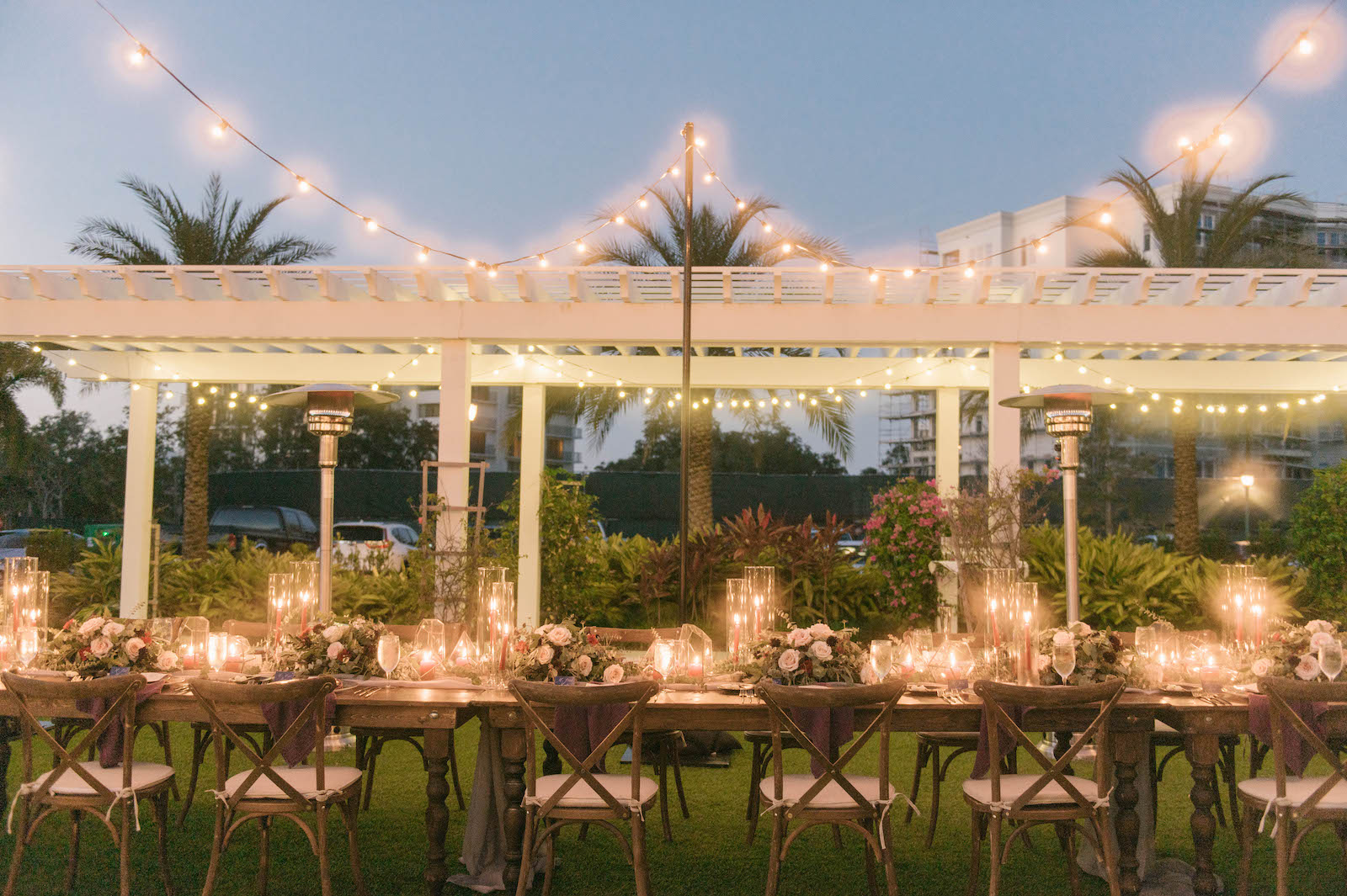 Boho Garden Outdoor Wedding Reception, Long Wooden Feasting Table, White Pergola, Wooden Cross back Chairs, Candles, Low Floral Centerpieces, String Lights | Tampa Bay Wedding Planner Parties A'la Carte | Belleair Wedding Venue Belleview Inn