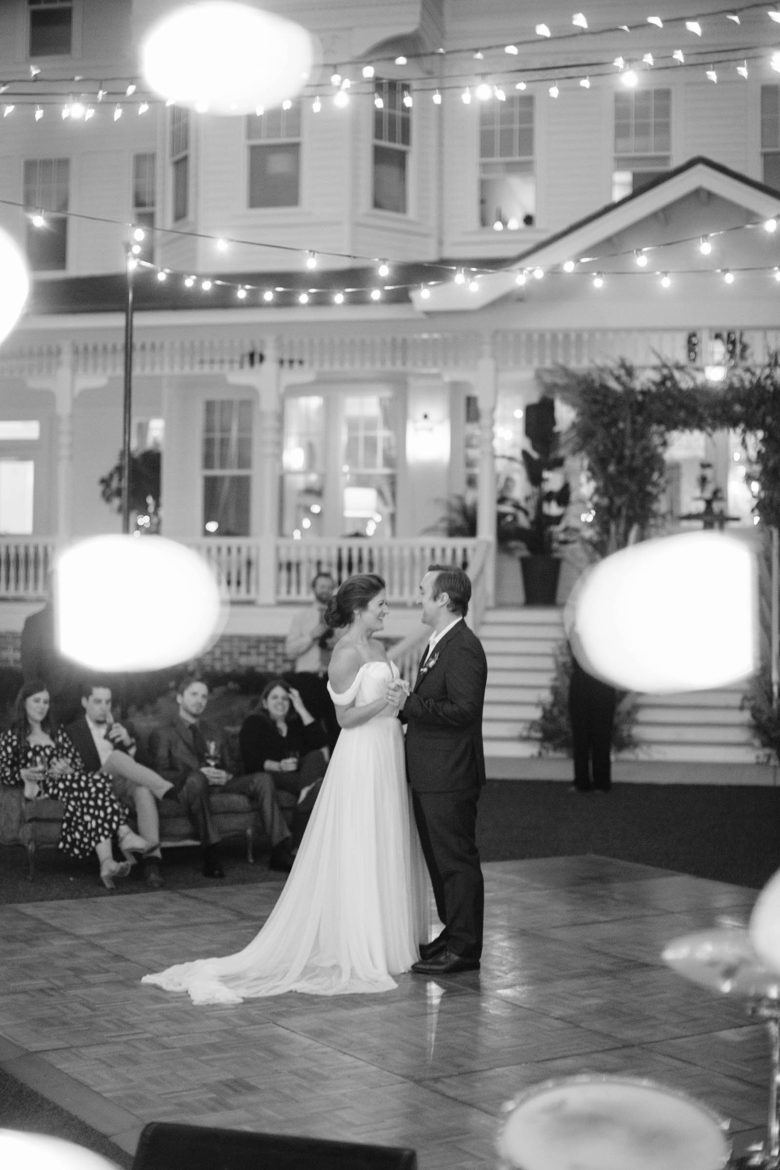 Boho Garden Wedding Reception, Bride and Groom Dancing Under String Lights Black and White Photo | Tampa Bay Wedding Planner Parties A'la Carte | Florida Wedding Venue Belleview Inn