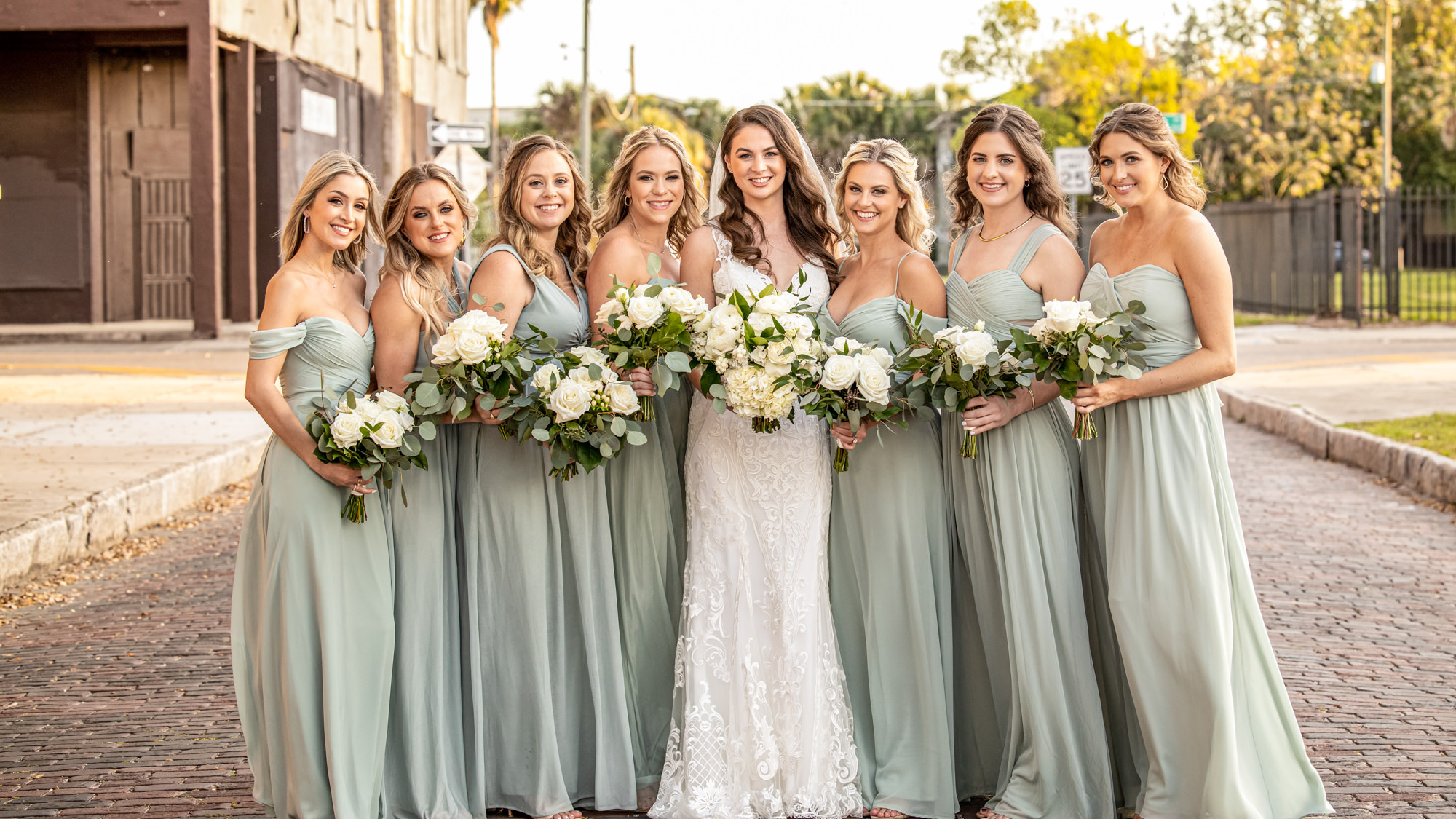 Flowing Sage Green Mismatched Bridesmaids Dresses with White and Greenery Wedding Bouquets
