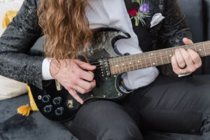 Modern Rock N Roll Groom Wearing Custom Leather Black Jacket Playing Electric Guitar | Tampa Bay Wedding Photographer Amanda Zabrocki Photography | Styled Shoot