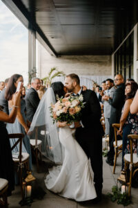 Modern Boho Bride and Groom Kissing After Exchanging Wedding Vows During Recessional at Wedding Ceremony | Tampa Bay Wedding Florist Iza's Flowers