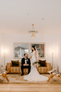 Modern Boho Bride and Groom Sitting on Retro Brown Leather Couch at Unique South Tampa Wedding Venue Hyde House