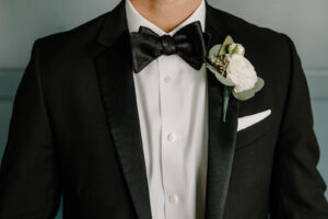 Modern Boho Groom Wearing Black Tuxedo with White Rose and Eucalyptus Leaves Flower Boutonniere | Tampa Bay Wedding Florist Iza's Flowers
