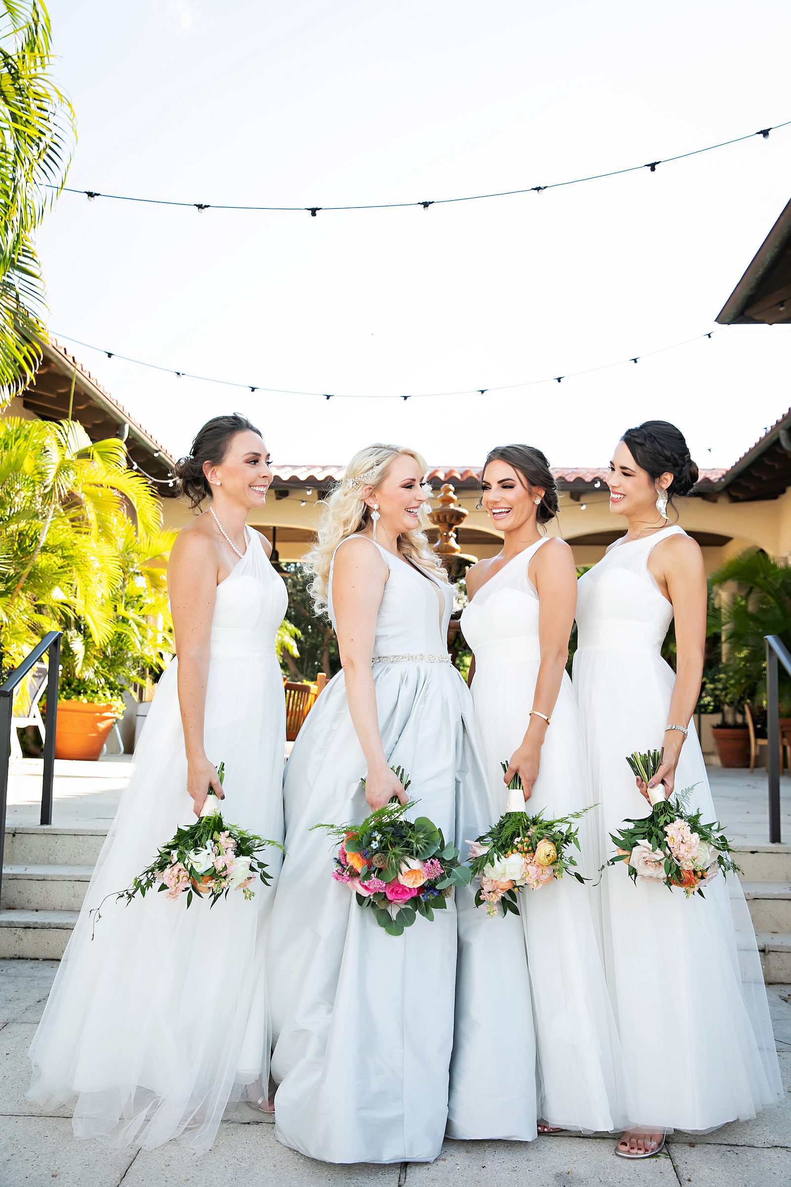 Bride and Bridesmaids in White Floor Length Bridesmaids Dresses Wedding Portrait with Bright Orange and Pink Floral Bouquets | Tampa Florida Photographer Limelight Photography | The Resort at Longboat Key Club