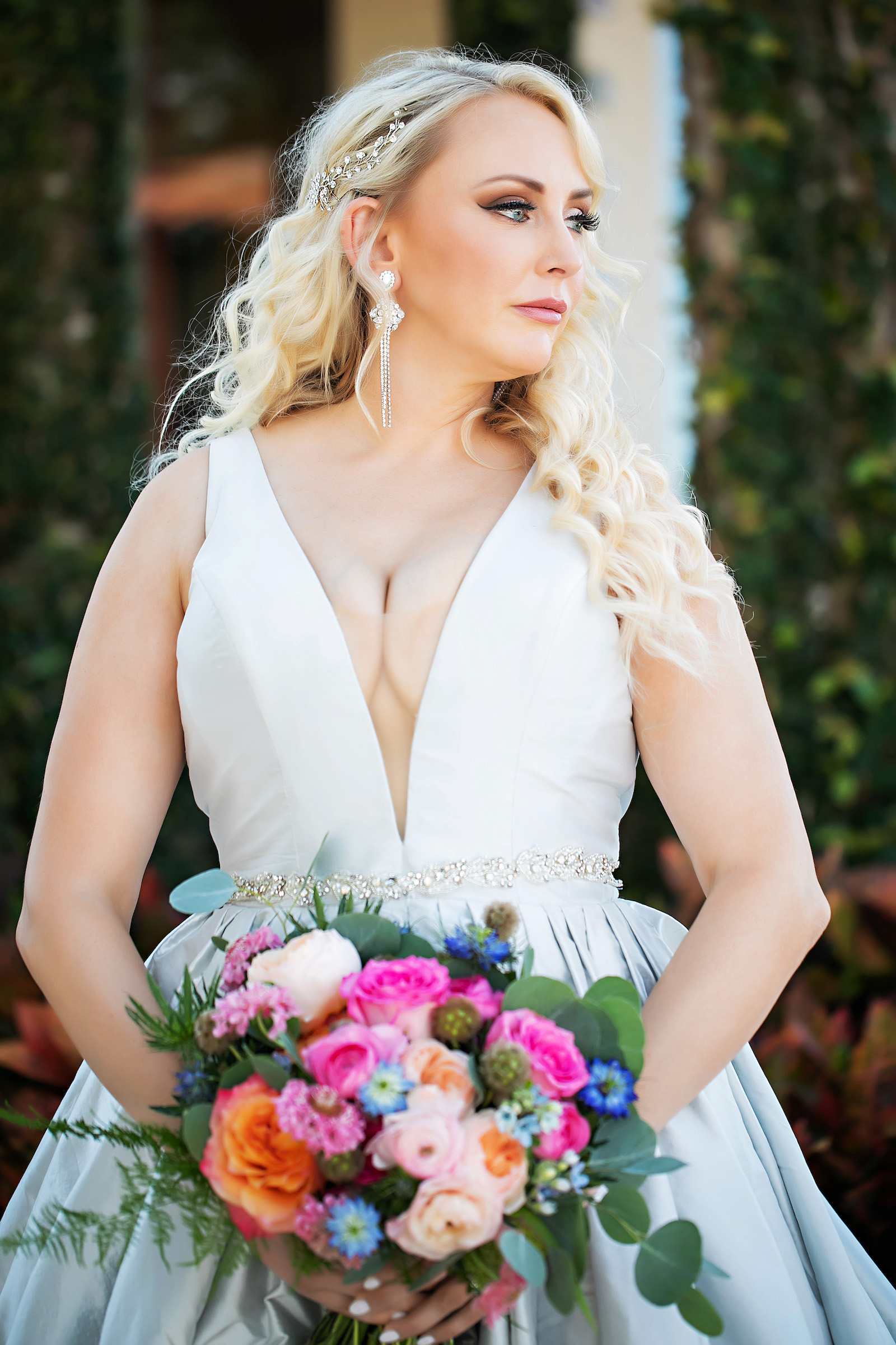 Bride with Classic Smokey Eye and Soft Curl Hair Down Bridal Look and Bright Orange and Pink Floral Bouquet with Greenery in Deep V Classic Wedding Ballgown Portrait | Florida Hair and Makeup Artist Femme Akoi