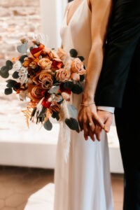 Bridal Bouquet with Greenery, Orange and Burgundy Florals with White Details | Bride and Groom Wedding Portrait