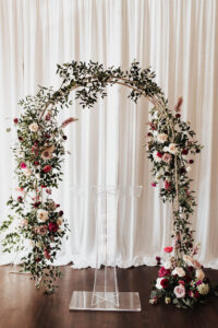 Warm Neutral Romantic Wedding Ceremony Decor, Rounded Arch with Greenery, White and Berry Colored Flowers, Acrylic Stand | Tampa Bay Wedding Planner Coastal Coordinating | Wedding Rentals Kate Ryan Event Rentals