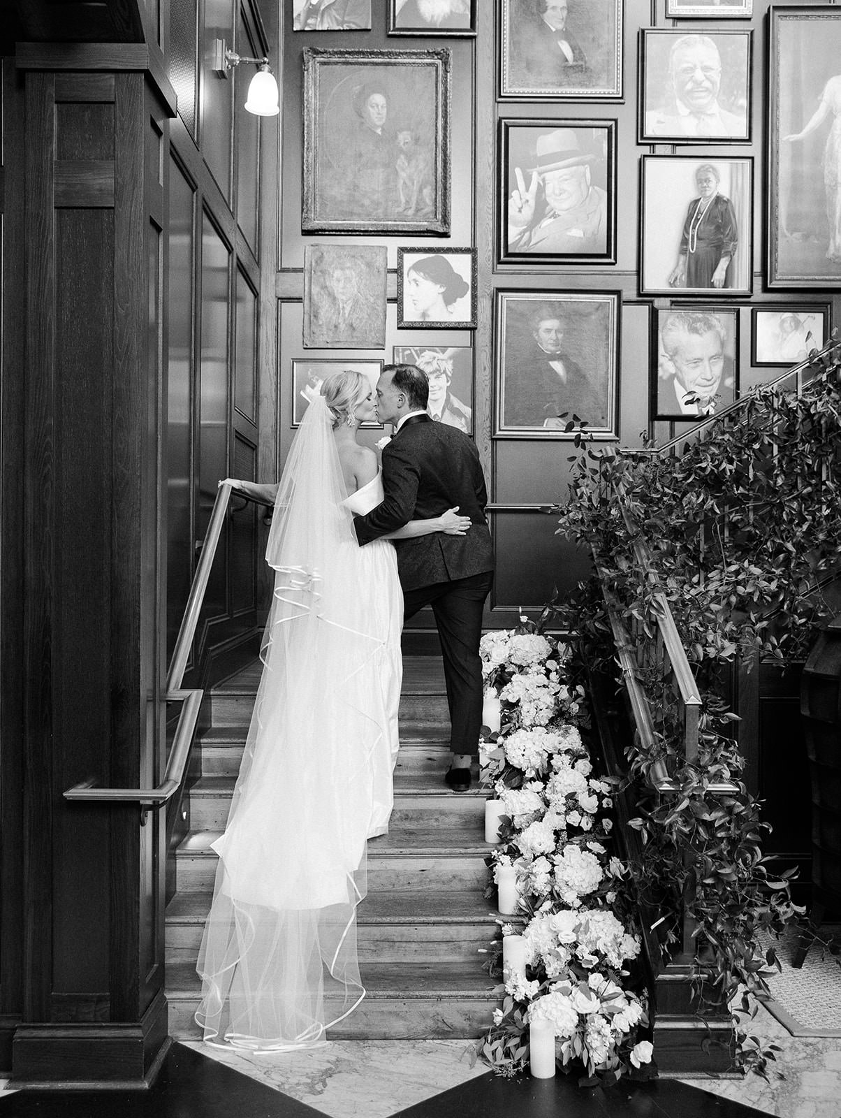 Classic Elegant Bride and Groom Kissing on Staircase | Tampa Bay Wedding Florist Botanica | Wedding Venue Oxford Exchange