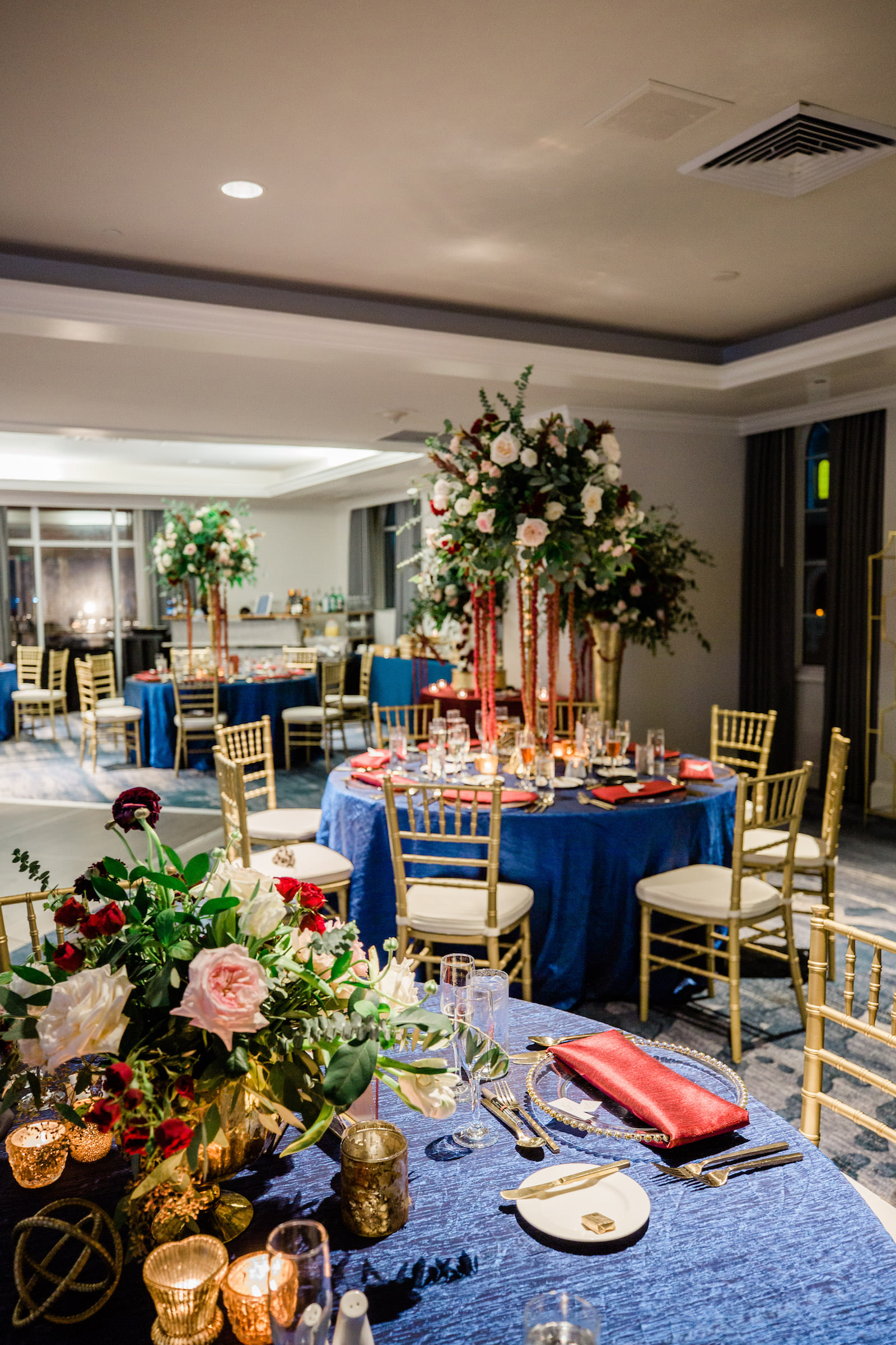 Elegant Navy Wedding Reception Decor, Tall Gold Vase with Greenery, Blush Pink and White Roses, Dark Purple and Red Flowers with Hanging Amaranthus Flower Centerpiece, Navy Blue Table Linen, Gold Chiavari Chairs | Tampa Bay Wedding Florist Botanica | St. Petersburg Wedding Venue The Don Cesar