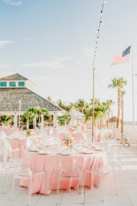 Tropical Old Florida Waterfront Sarasota Wedding Reception with Peach Linens and Acrylic Ghost Chairs