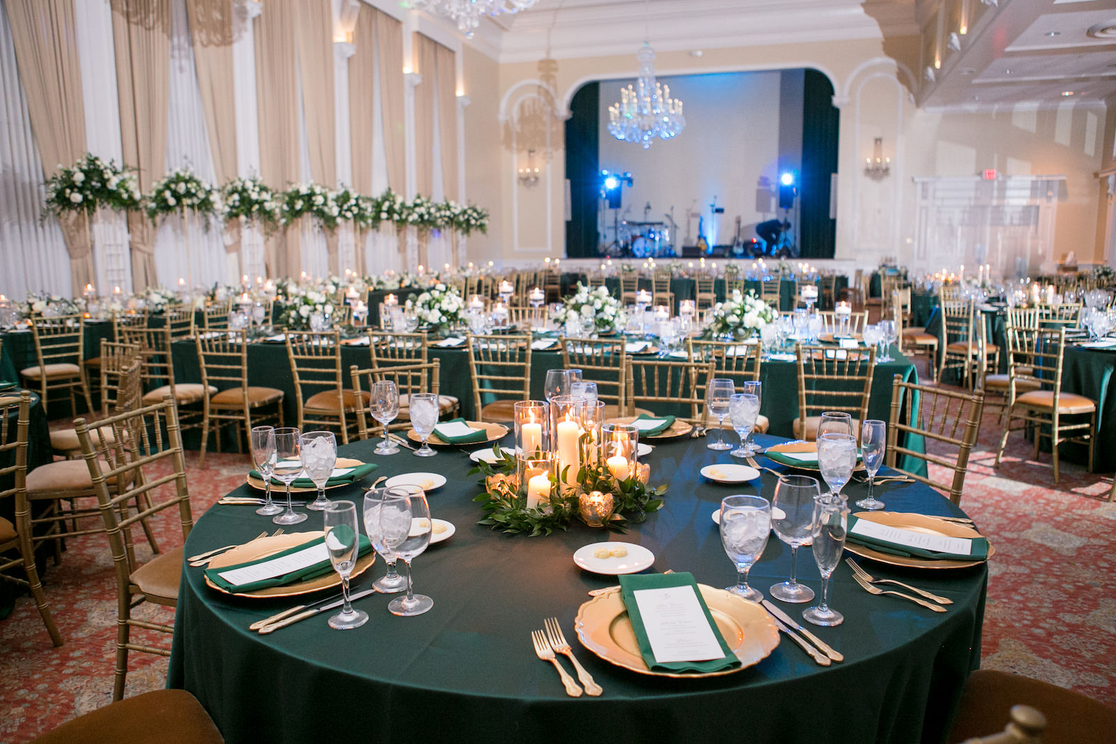 Green and Gold Christmas Wedding Decor, Long and Round Tables with Emerald Green Table Linens, Gold Chiavari Chairs, Gold Chargers, White and Greenery Low and Tall Floral Centerpieces, Gold Monogram on Dance Floor | Tampa Bay Wedding Photographer Carrie Wildes Photography | Wedding Rentals Kate Ryan Event Rentals | Over the Top Rental Linens | A Chair Affair Event Rentals | Tampa Wedding Venue Palma Ceia Golf & Country Club