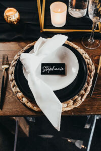 Black and White Place Setting with Woven Charger and Gold Flatware | Gabro Event Rental Services