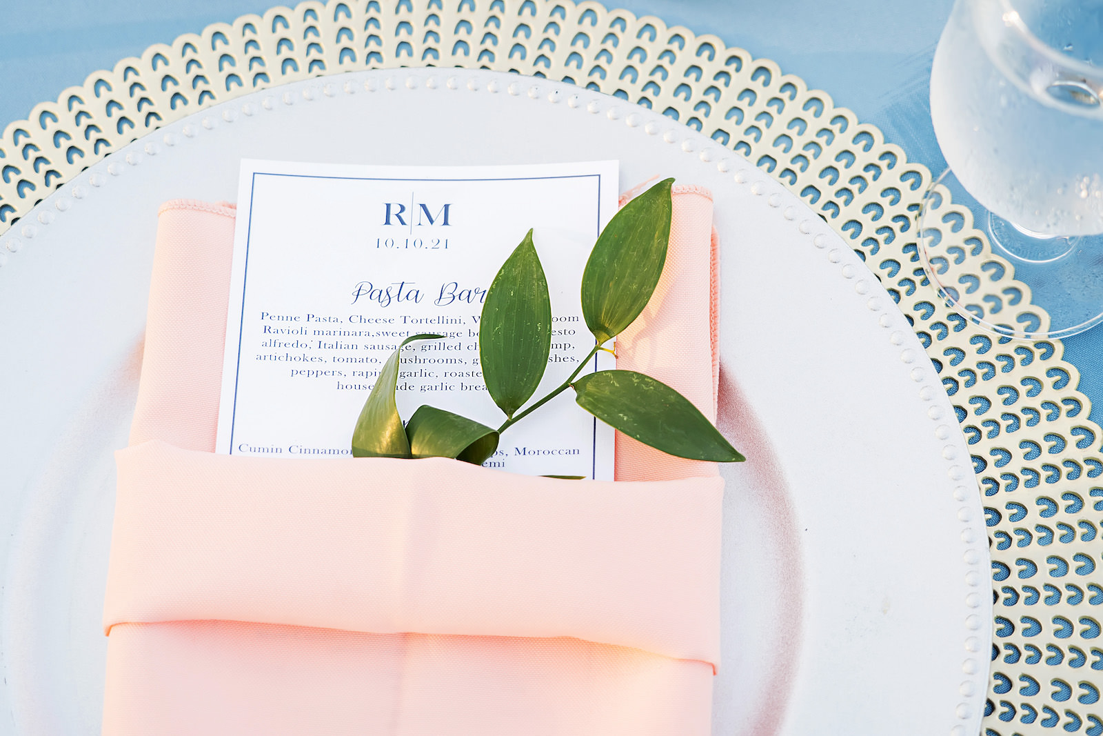 Elegant Place Setting with Peach Napkin and Greenery Detailing
