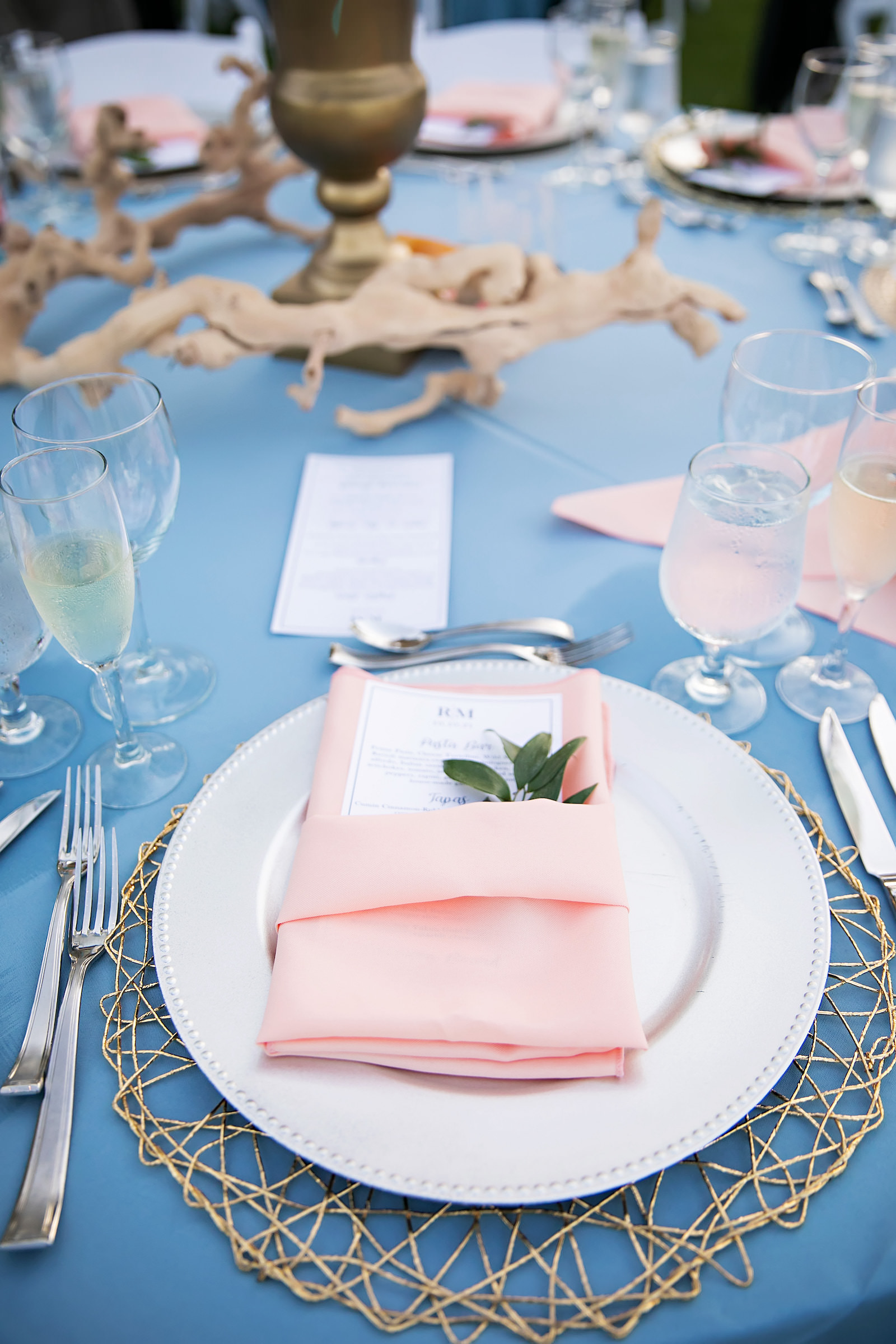 Elegant Place Setting with Peach Napkin and Greenery Detailing and Dusty Blue Linen