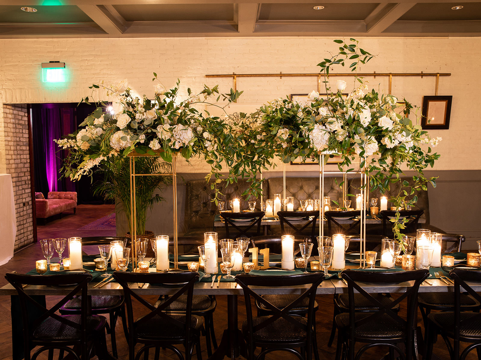 Classic Elegant Wedding Reception Decor, Long Feasting Tables, Black Cross Back Chairs, Green Linen Table Runners, Candles, Tall Gold Stands with Lush White Flowers and Greenery | Tampa Bay Wedding Florist Botanica | Wedding Venue Oxford Exchange | A Chair Affair Rentals