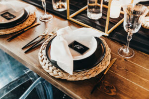 Black and White Place Setting with Woven Charger and Gold Flatware | Gabro Event Rental Services