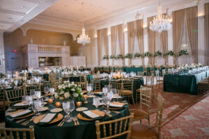 Green and Gold Christmas Wedding Decor, Long and Round Tables with Emerald Green Table Linens, Gold Chiavari Chairs, Gold Chargers, White and Greenery Low and Tall Floral Centerpieces, Gold Monogram on Dance Floor | Tampa Bay Wedding Photographer Carrie Wildes Photography | Wedding Rentals Kate Ryan Event Rentals | Over the Top Rental Linens | A Chair Affair Event Rentals | Tampa Bay Wedding Venue Palma Ceia Golf & Country Club