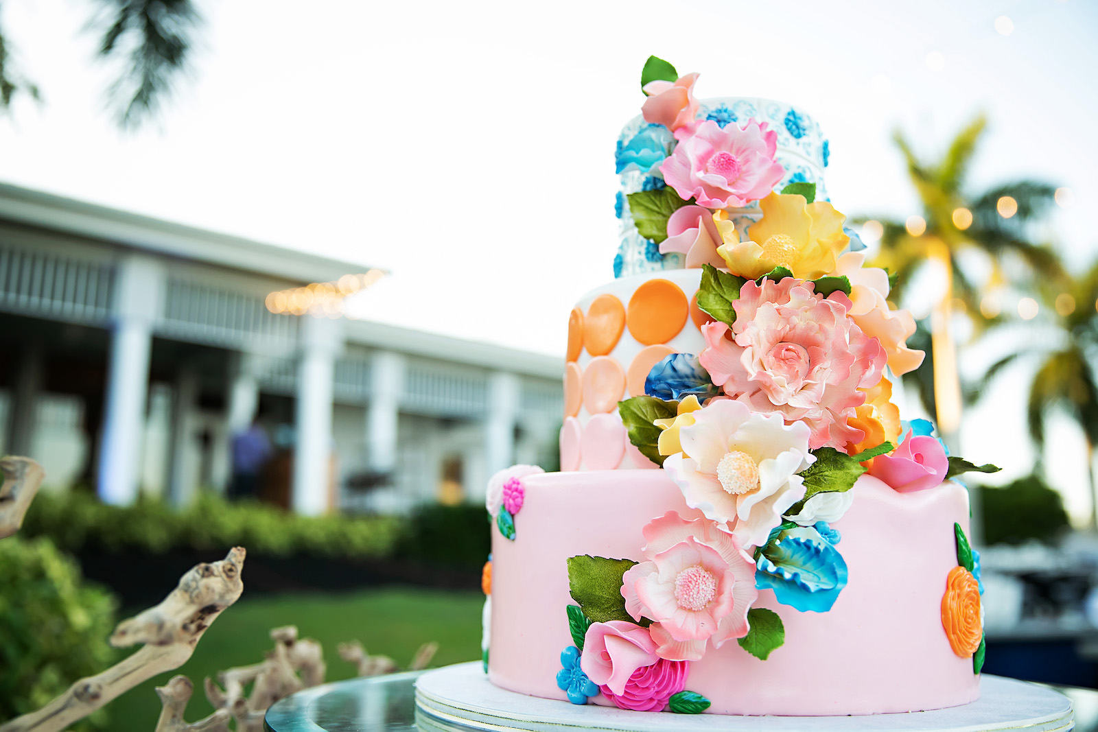 Three Tier Bright and Vibrant Floral Cake with Blue, Orange, and Pink Detailing