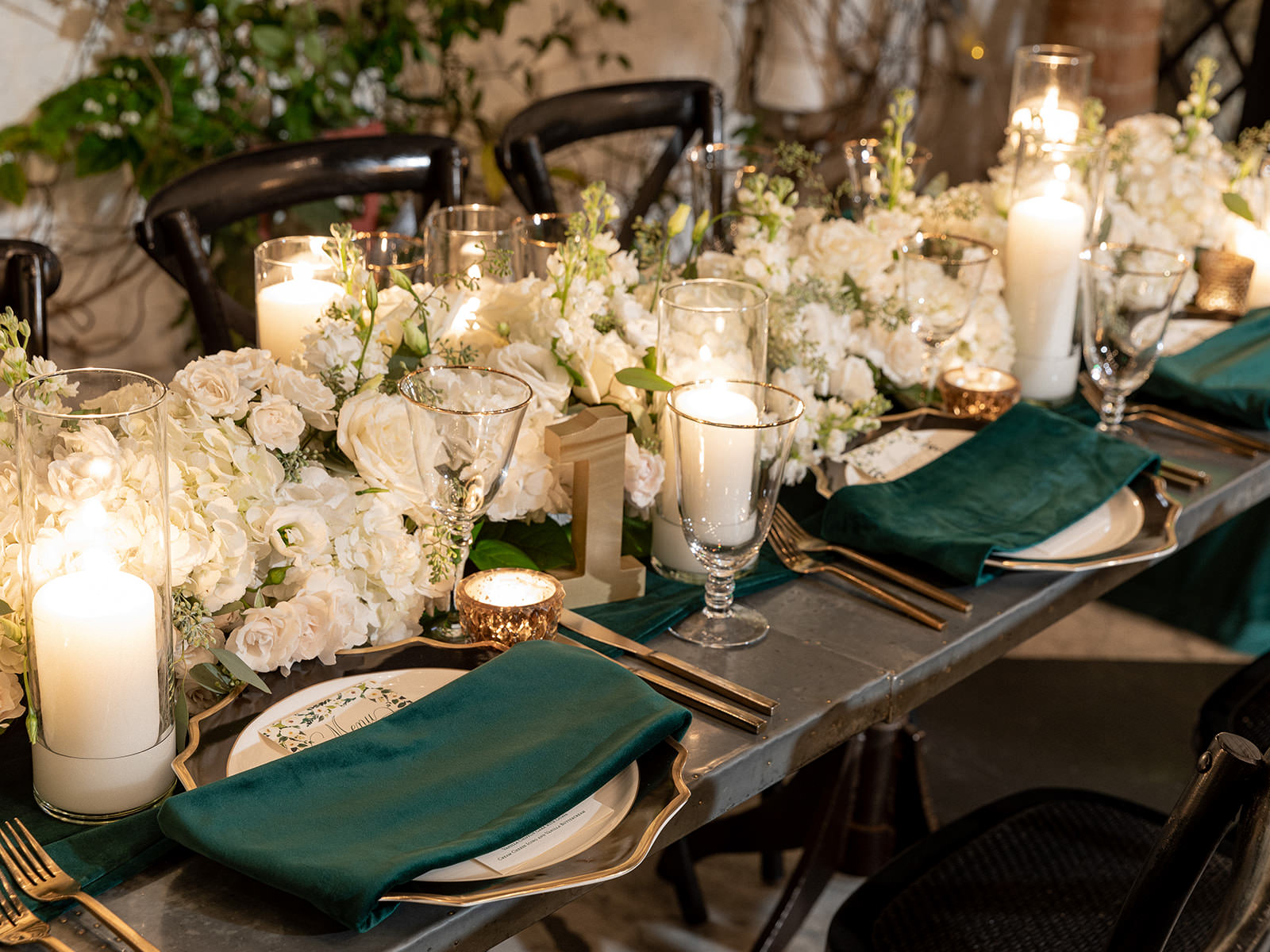 Classic Elegant Wedding Reception Decor, Gold Rimmed Scalloped Chargers, Emerald Green Linen Napkins, Lush White Roses and Hydrangeas Floral Table Runner, Candles, Gold Flatware | Tampa Bay Wedding Florist Botanica | A Chair Affair Rentals