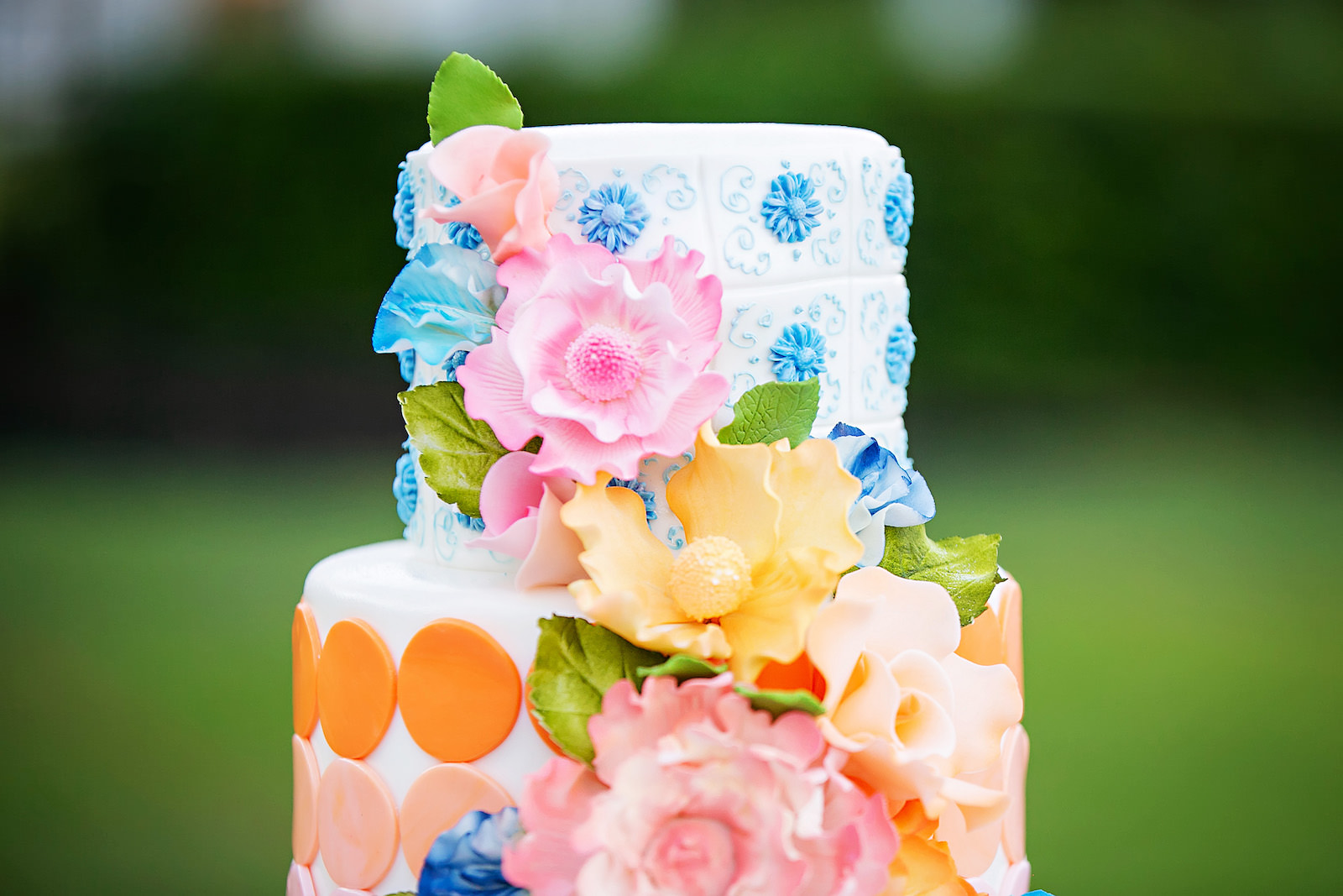 Three Tier Bright and Vibrant Floral Cake with Blue, Orange, and Pink Detailing