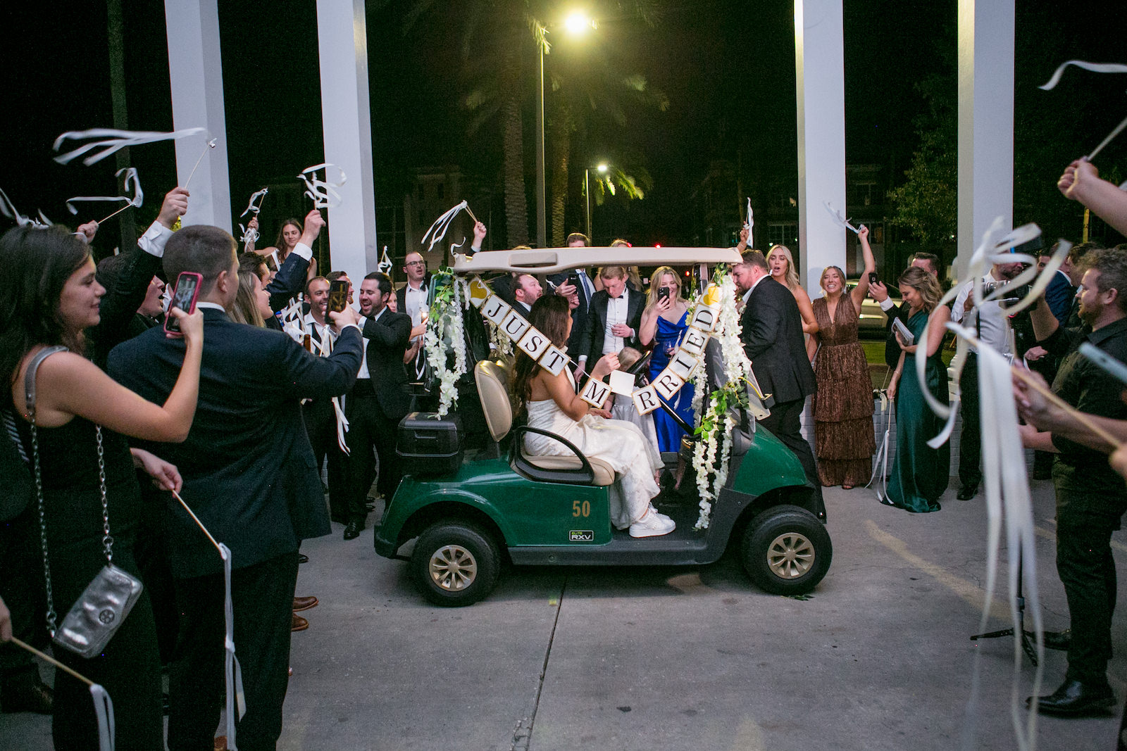 Green and Gold Christmas Wedding, Bride Wearing Wedding Jumpsuit and Groom in Golf Cart, Ribbon Reception Exit | Tampa Bay Wedding Photographer Carrie Wildes Photography