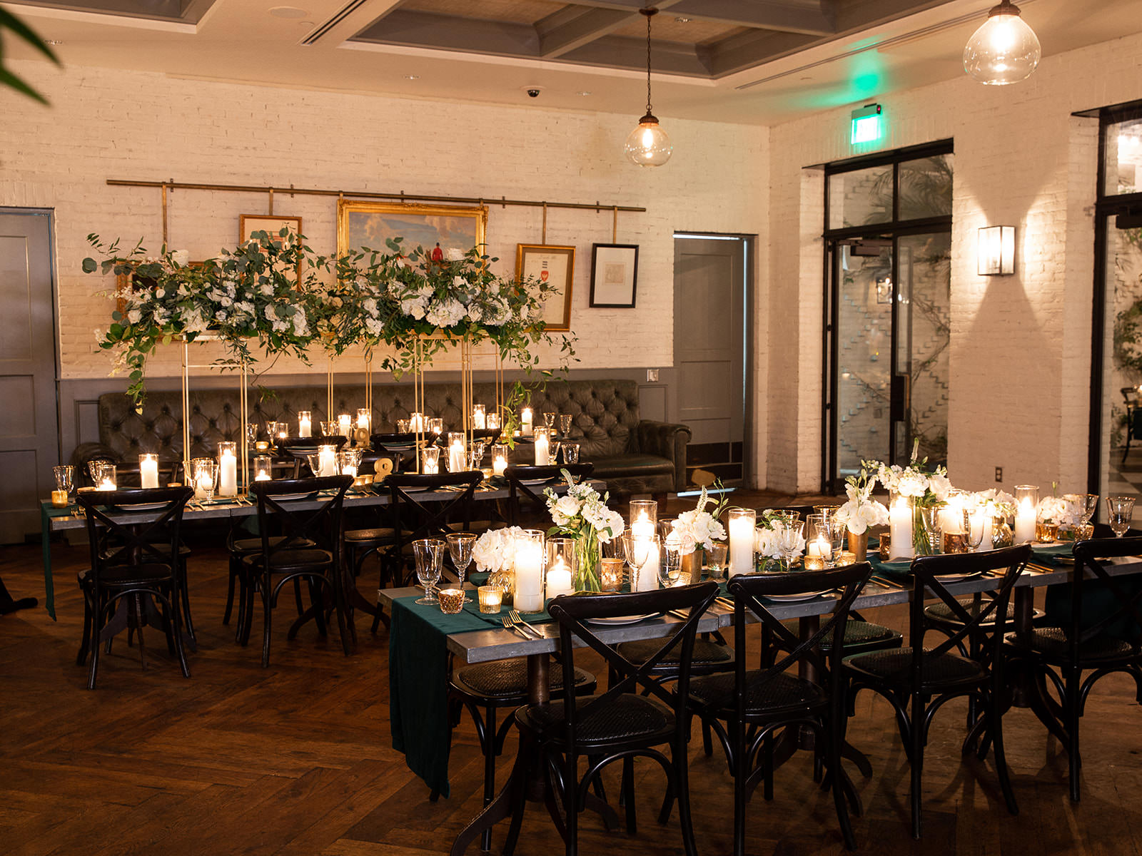 Classic Elegant Wedding Reception Decor, Long Feasting Tables, Black Cross Back Chairs, Green Linen Table Runners, Candles, Tall Gold Stands with Lush White Flowers and Greenery | Tampa Bay Wedding Florist Botanica | Wedding Venue Oxford Exchange
