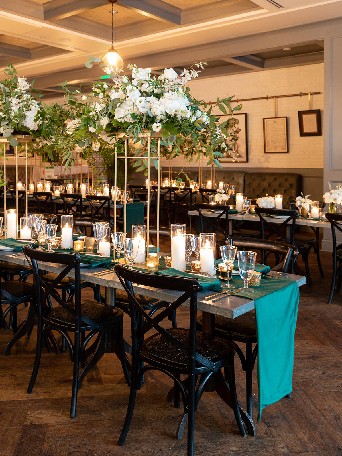 Classic Elegant Wedding Reception Decor, Long Feasting Tables, Black Cross Back Chairs, Green Linen Table Runners, Candles, Tall Gold Stands with Lush White Flowers and Greenery | Tampa Bay Wedding Florist Botanica | Wedding Venue Oxford Exchange | A Chair Affair Rentals