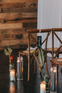 Wooden Cross Back Chairs with Palm and Candle Aisle Décor Detail | Tampa Florida Wedding Rentals Gabro Event Services
