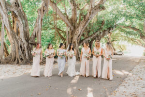 Bride and Bridesmaids in Pastel Floor Length Bridesmaids Dresses in Tropical Wedding Ceremony