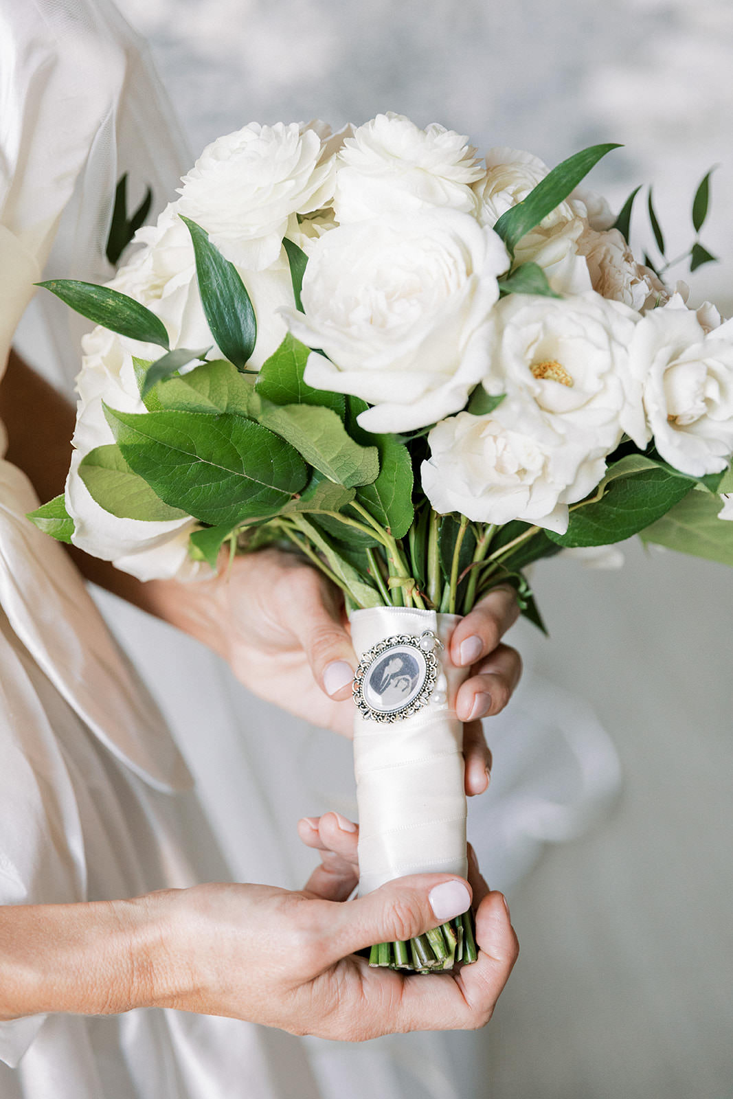 Bride Holding Classic All White Roses Bouquet with Greenery Leaves and Memory Remembrance Bouquet Charm | Tampa Bay Wedding Florist Botanica International Design Studio