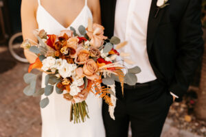 Bridal Bouquet with Greenery, Orange and Burgundy Florals with White Details | Bride and Groom Wedding Portrait