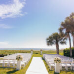 Waterfront Modern Elegant Wedding Ceremony Decor, White Folding Chairs, White Pedestals with Round White Roses Floral Arrangements | Tampa Wedding Venue The Resort at Longboat Key Club