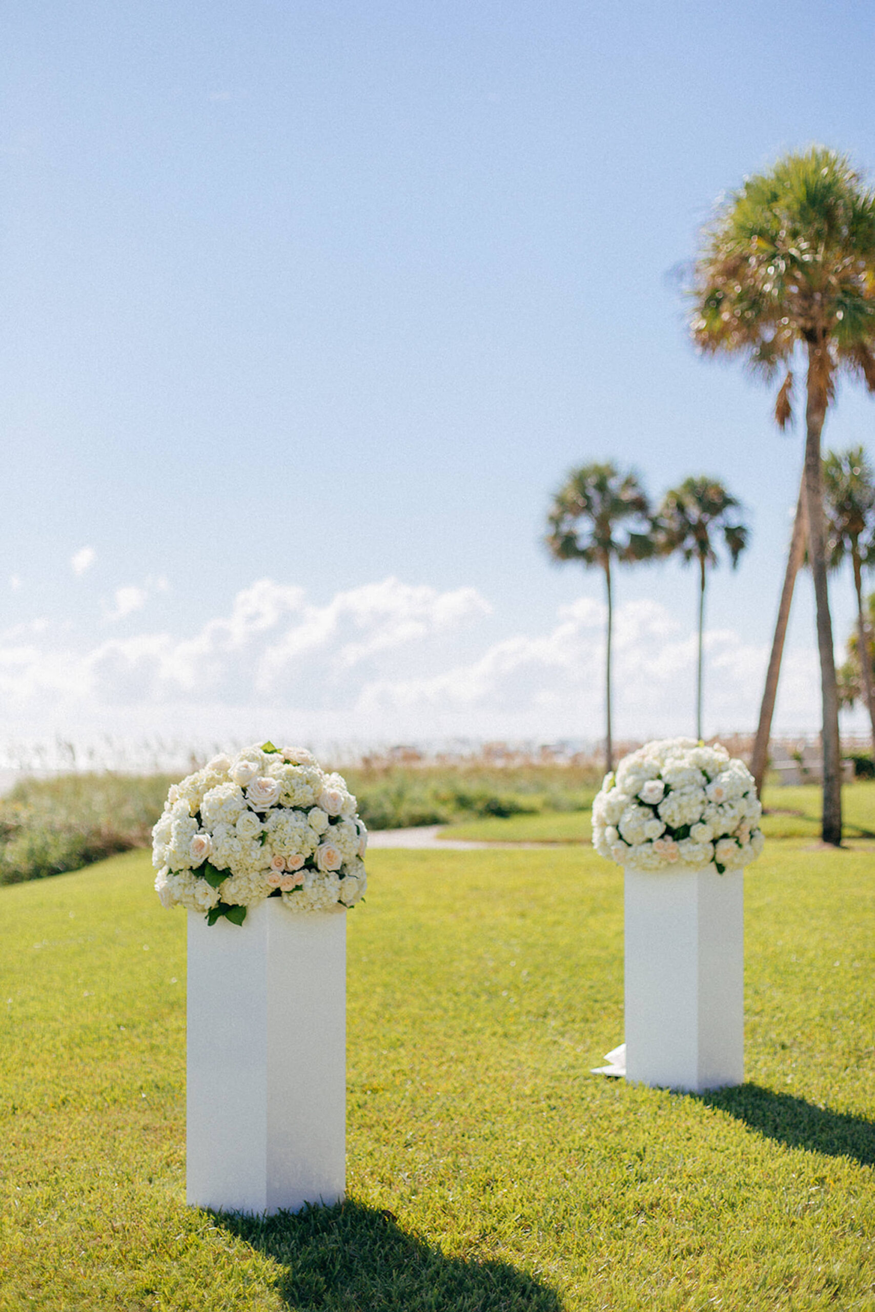 Waterfront Modern Elegant Wedding Ceremony Decor, Two White Pedestals with Round Classic White Roses Floral Arrangements | Tampa Bay Wedding Venue The Resort at Longboat Key Club
