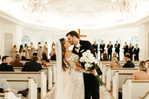 Bride and Groom First Kiss in Timeless Neutral White and Black Safety Harbor Chapel Wedding Ceremony | Harborside Chapel