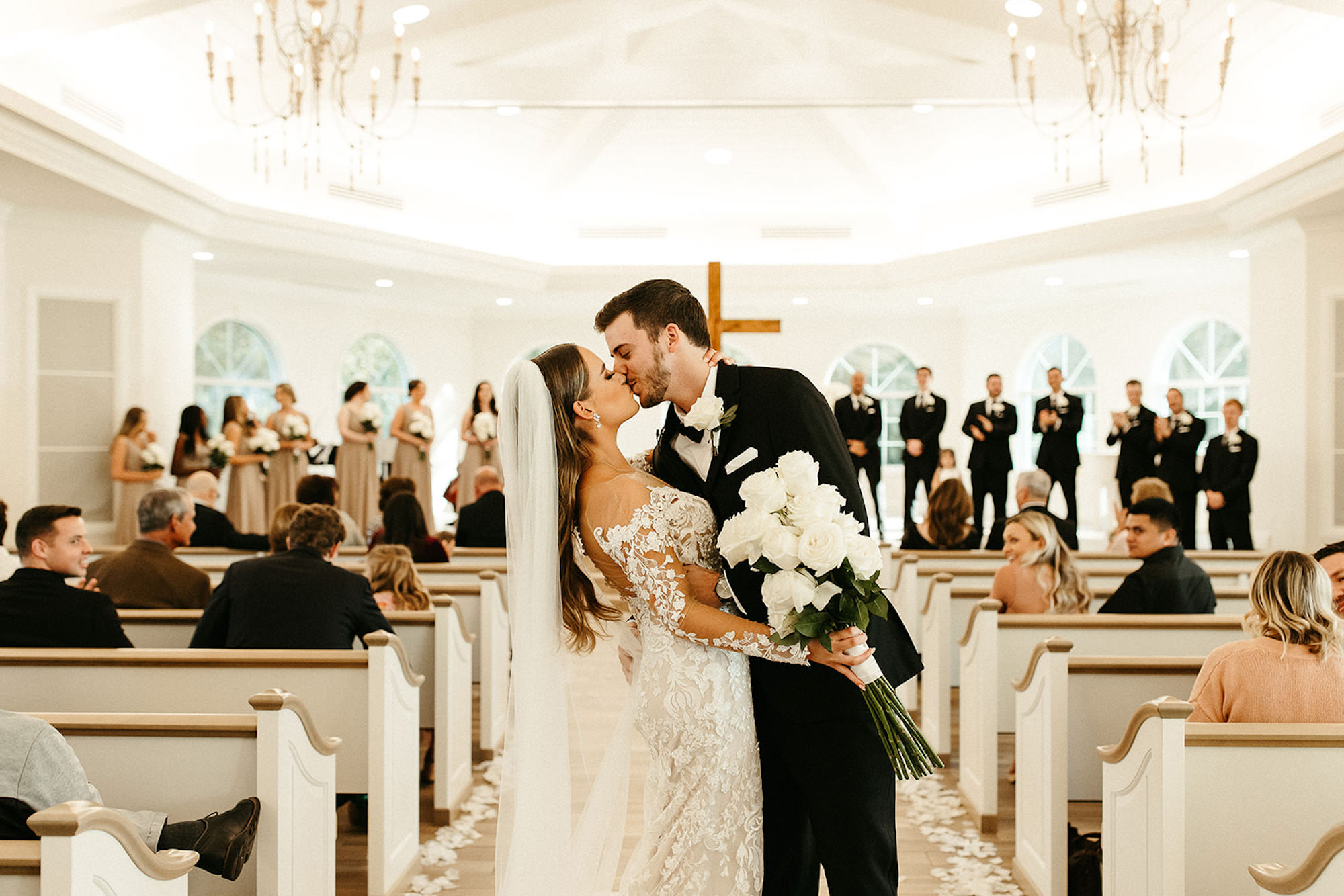 Bride and Groom First Kiss in Timeless Neutral White and Black St. Petersburg Chapel Wedding Ceremony | Harborside Chapel