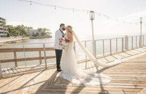 Bride and Groom Kissing on Waterfront Dock | The Godfrey