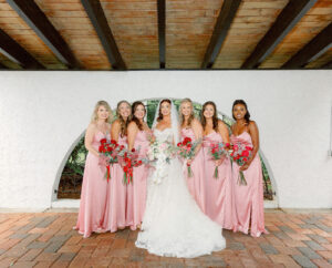 Fairytale Private Residence Wedding, Bride and Bridesmaids Wearing Matching Silk Pink Dresses Holding Red Roses with Babys Breathe Floral Bouquets | Tampa Bay Wedding Photographer Dewitt for Love Photography | Wedding Florist Lemon Drops