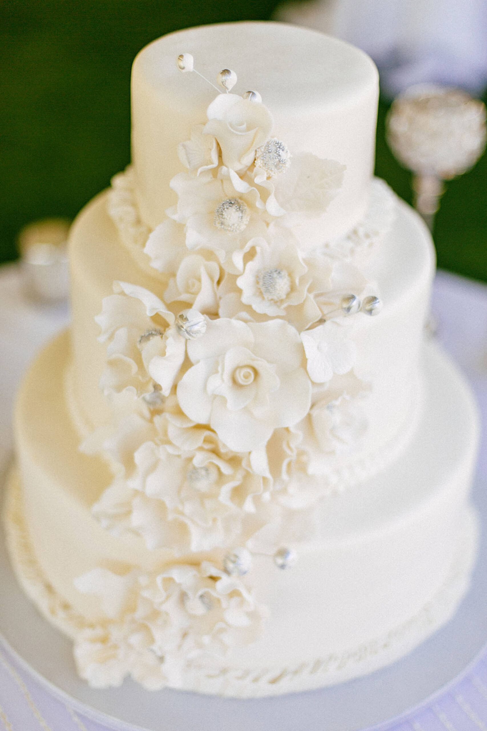 Three Tier All White Wedding Cake with White and Silver Accent Sugar Flowers Cascading Side