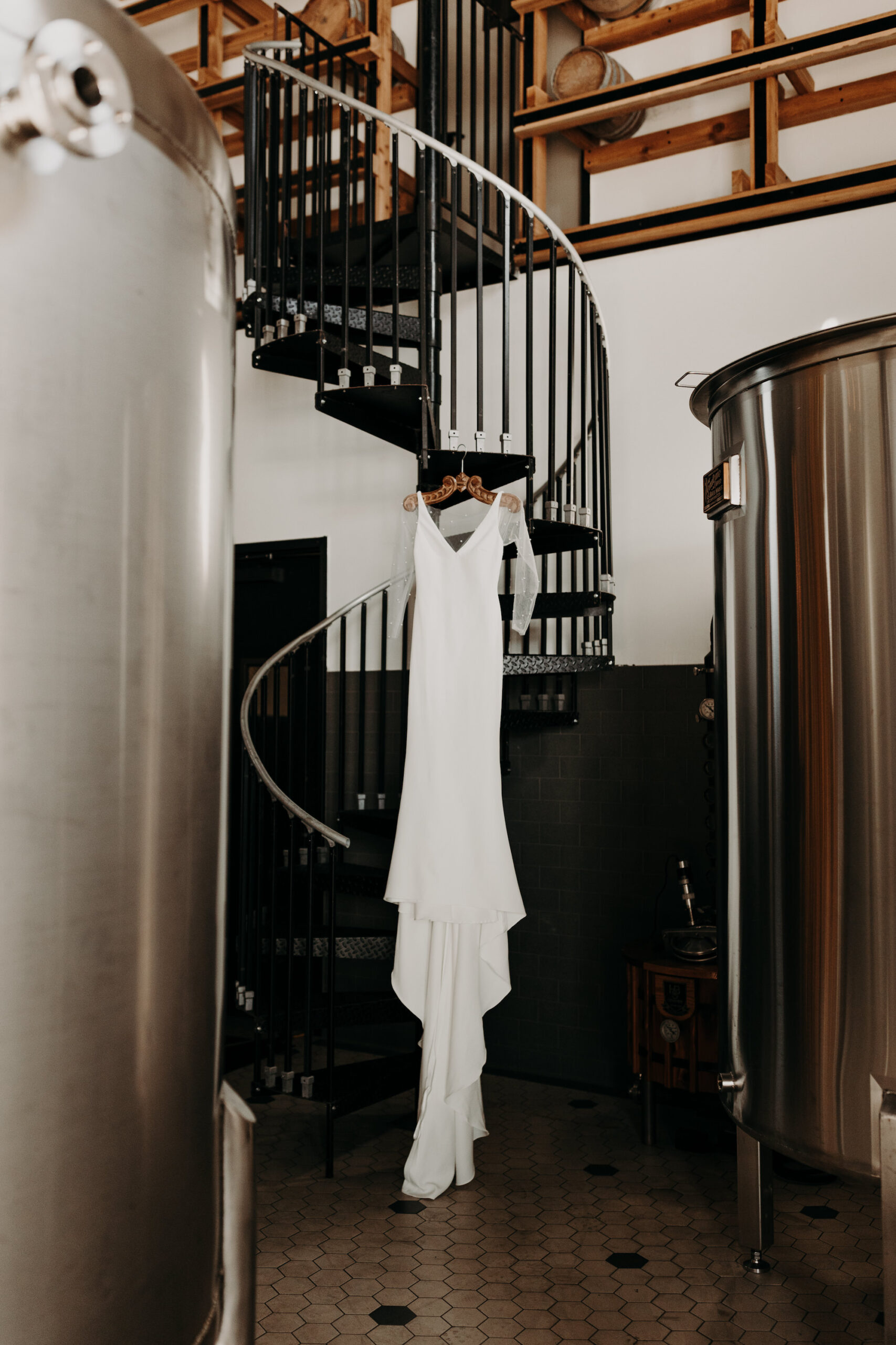 Sheer Long Sleeve Detailed Wedding Dress with Sleek Fit on Hanger in Industrial Building Wedding Portrait | Tampa Venue Urban Stillhouse